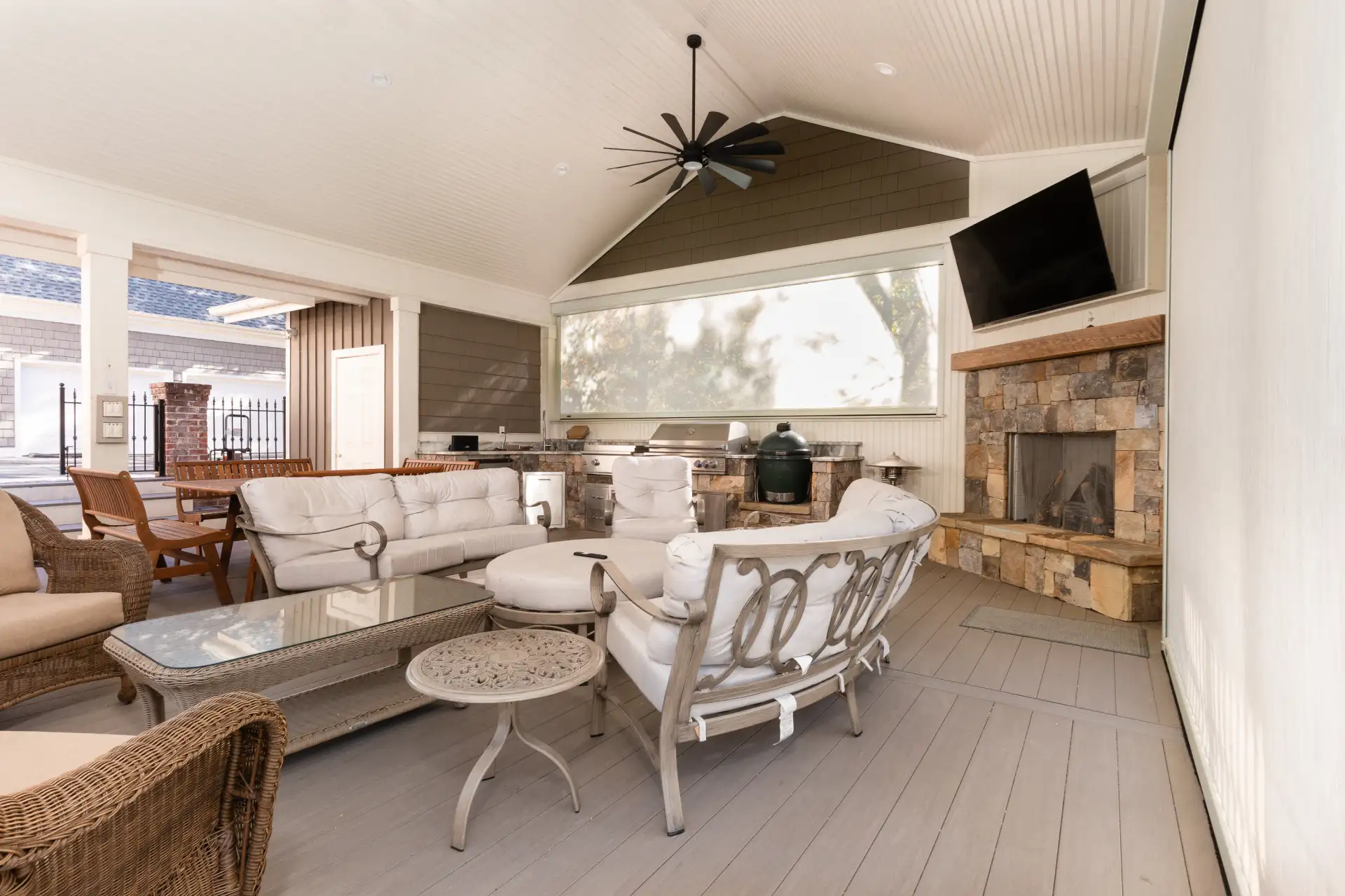 MagnaTrack™ Retractable Screens surrounding an outdoor kitchen and entertainment area