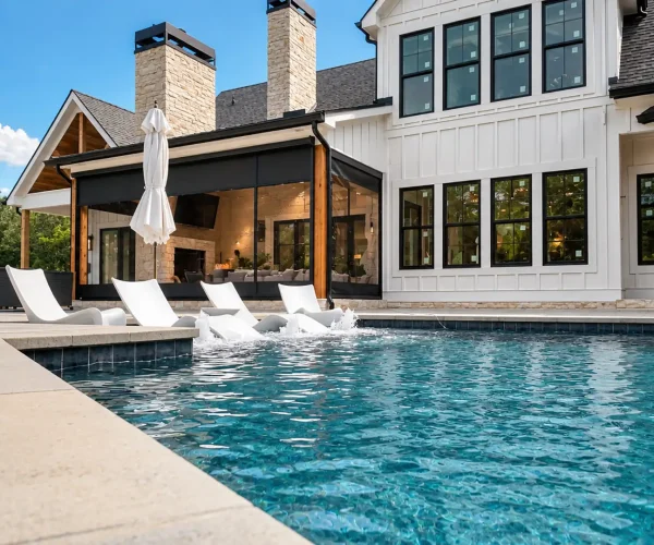 Custom-made motorized retractable screens help enclose this poolside pavilion while preserving the view and connection to the outdoor space.